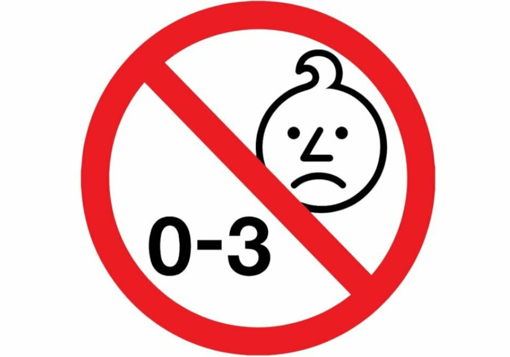Symbol zakazu z wizerunkiem smutnej twarzy dziecka i tekstem \'0-3\'.