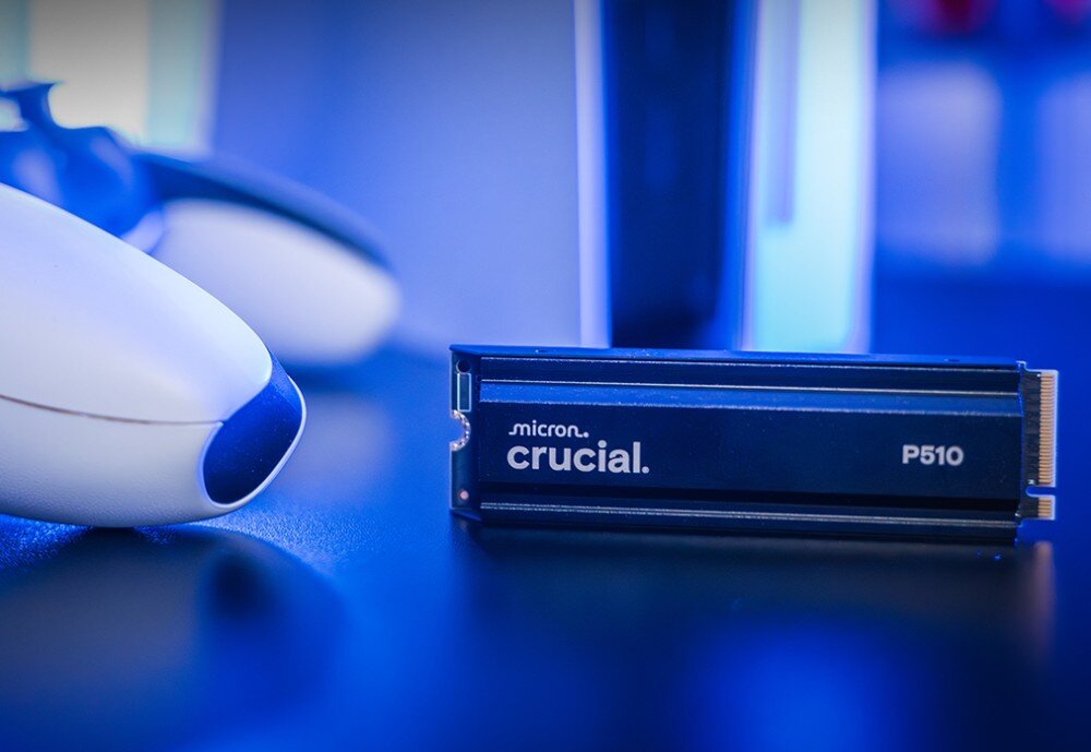 Dysk CRUCIAL P510 Dysk 'crucial P510' leży na ciemnym blacie, w tle rozmazany pad do konsoli i obudowa, pojemność
