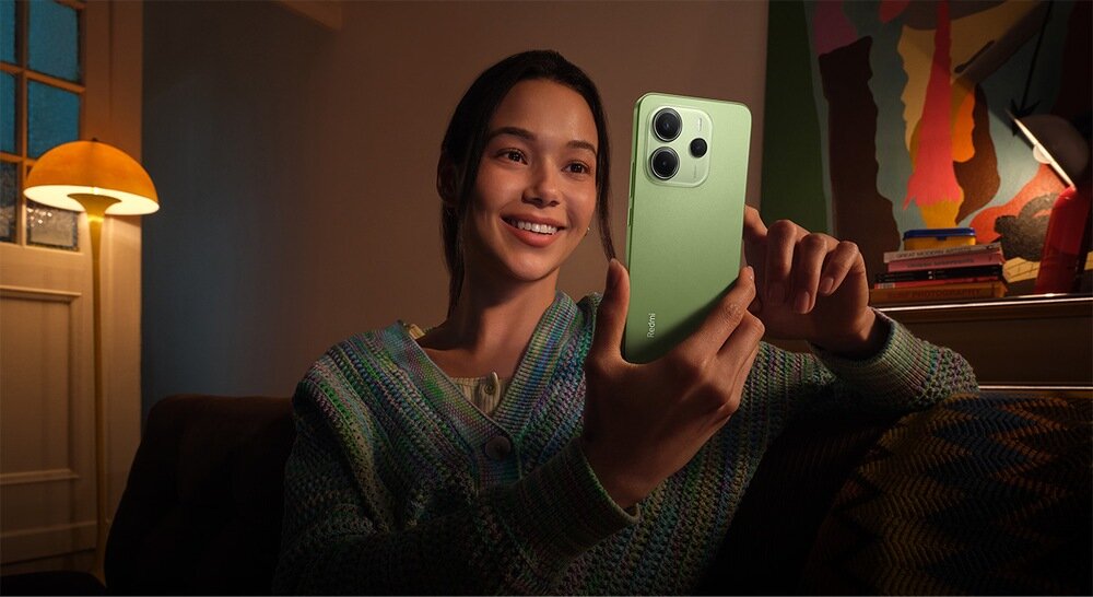 Smartfon XIAOMI Redmi Note 14 kobieta czyta na smartfonie po ciemku