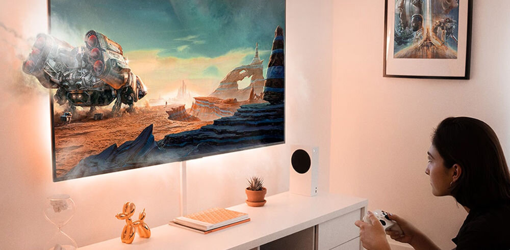 Telewizor LG 65QNED70A6A kontrolery Bluetooth gry w chmurze, osoba siedząca z kontrolerem w ręku, grająca w gry na telewizorze