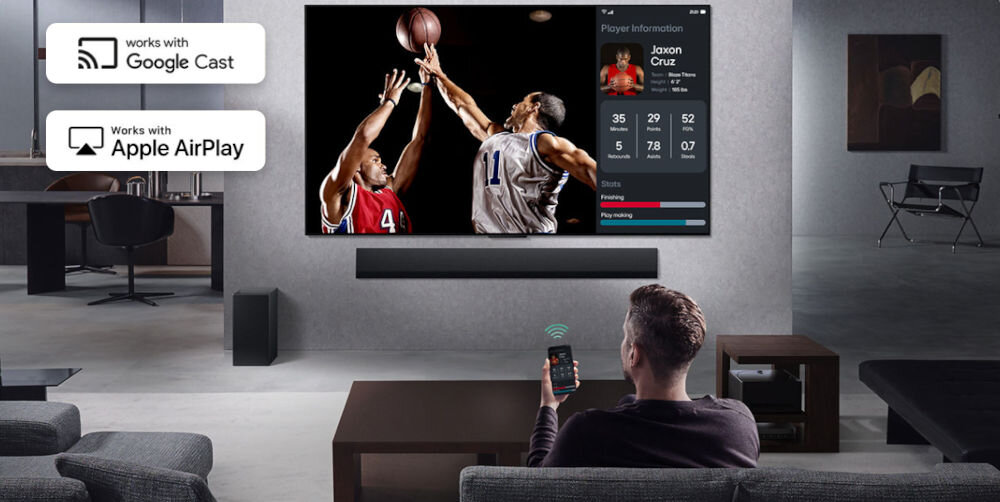 Telewizor LG 55QNED70A6A Multi View podzielony ekran, osoba siedząca na kanapie z telefonem w ręku, telewizor z soudbarem zawieszony na ścianie