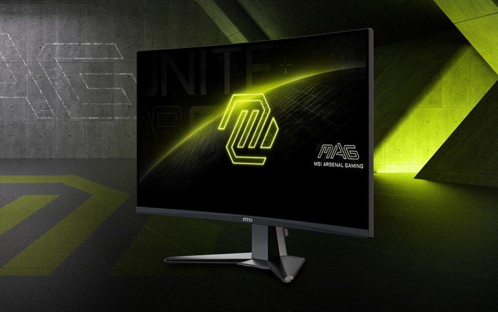 Monitor MSI Mag 276CXF Monitor gamingowy ustawiony na biurku, wyświetlający na ekranie logo serii na czarno-zielonym tle