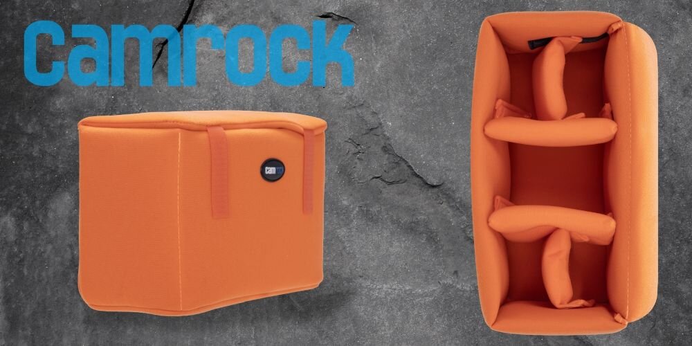 Baner z pomarańczowym wkładem z logo Camrock widoczny z boku i z góry nas szarym tle. W lewym górnym rogu duże niebieskie logo Camrock.