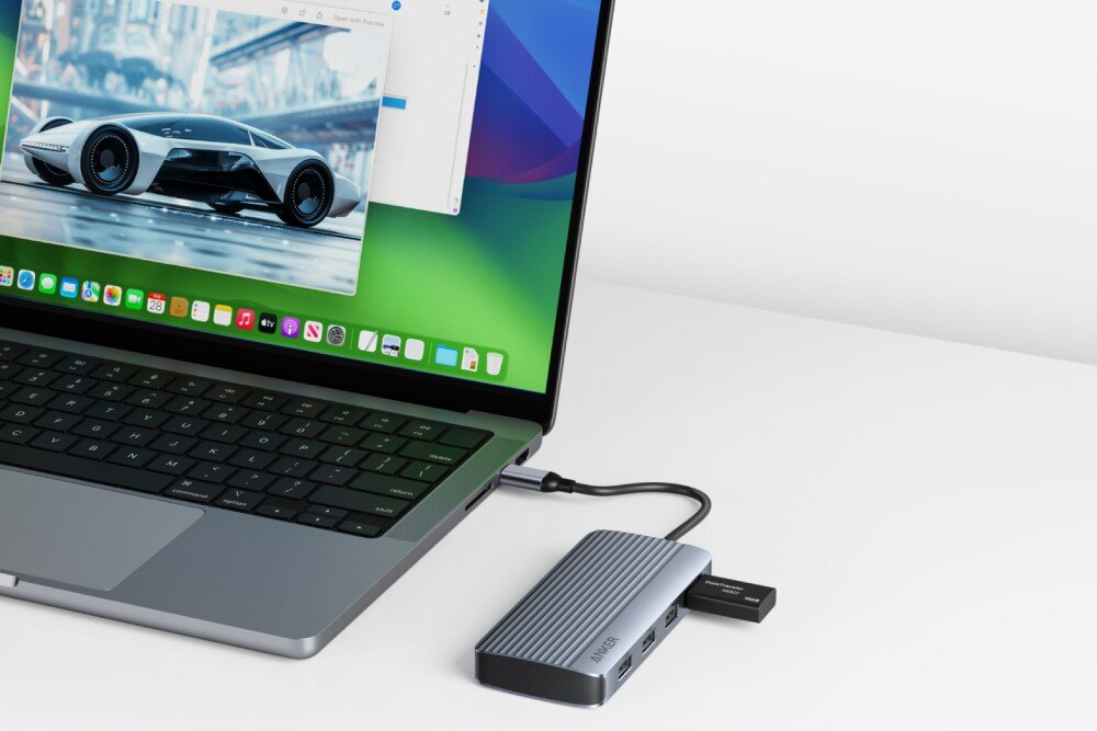 Hub ANKER A83740A1 7w1 Hub podłączony do bocznego portu srebrnego laptopa, z wpiętą jedną czarną pamięcią przenośną USB-A