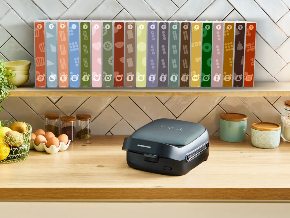 Opiekacz TEFAL Snack Collection SW862BF0 na blacie powyżej na półce komplet wymiennych płytek w pudełkach