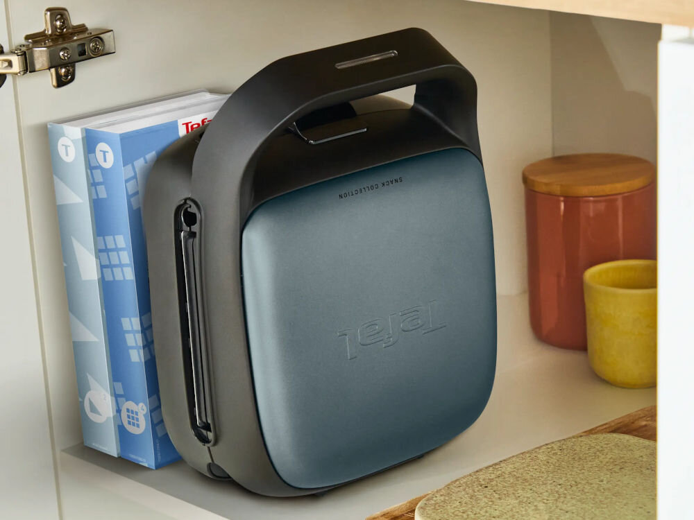 Opiekacz TEFAL Snack Collection SW862BF0 stojący pionowo na półce obok pudełek na płytki przechowywanie pionowo schowek na przewód wymienne płytki dedykowane pudełka