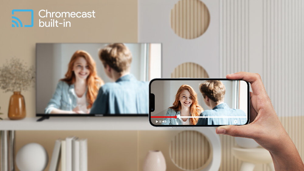 Telewizor TELEFUNKEN TFL-40APF1000 - Obraz ze smartfona na ekranie, Chromecast, Wi-Fi, telewizor stojący na stole, ręka trzymająca smartfona