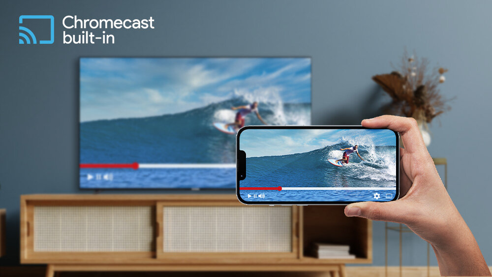 Telewizor TELEFUNKEN TFL-65AEU2000 - Przesyłaj z telefonu na TV, Chromecast, ręka trzymająca telefon w ręku, w tle telewizor stojący na komodzie