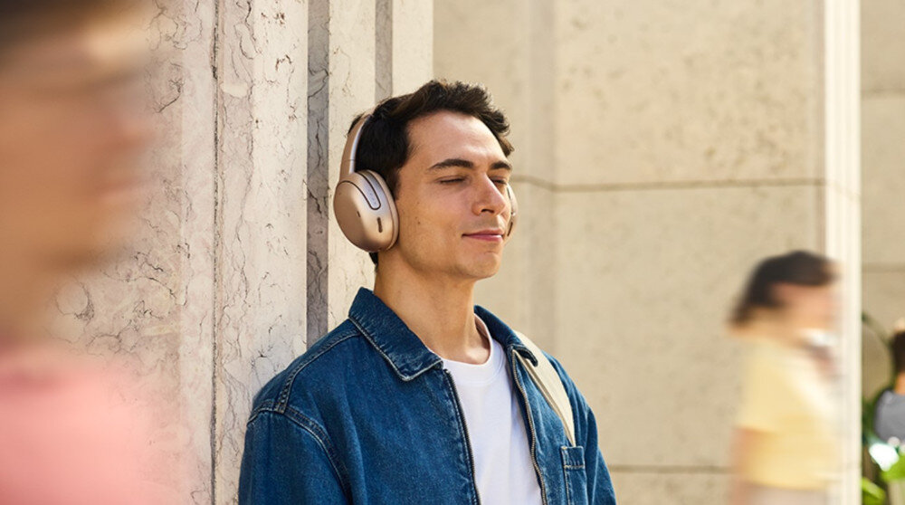 Słuchawki nauszne JBL TOUR ONE M3 - Redukcja hałasu, 8-mikrofonowego True Adaptive Noise Cancelling 2.0, Ambient Aware, TalkThru, osoba z założonymi słuchawkami