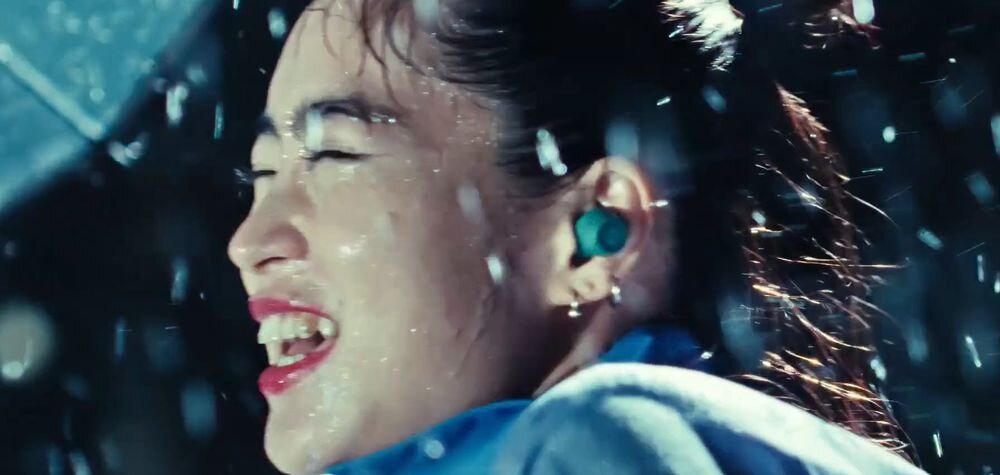 Słuchawki dokanałowe AUDIO-TECHNICA ATH-CKS30TW ANC aktywna redukcja hałasu tryb otoczenia, osoba z założonymi słuchawkami dokanałowymi skąpana w deszczu