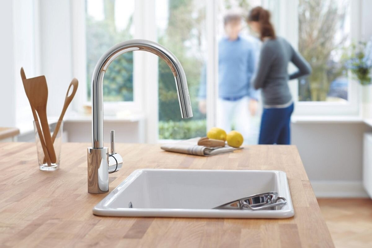 BATERIA KUCHENNA GROHE CONCETTO 31483002 CHROM Chromowana bateria kuchenna umieszczona przy białym zlewozmywaku na drewnianym blacie w jasnej kuchni