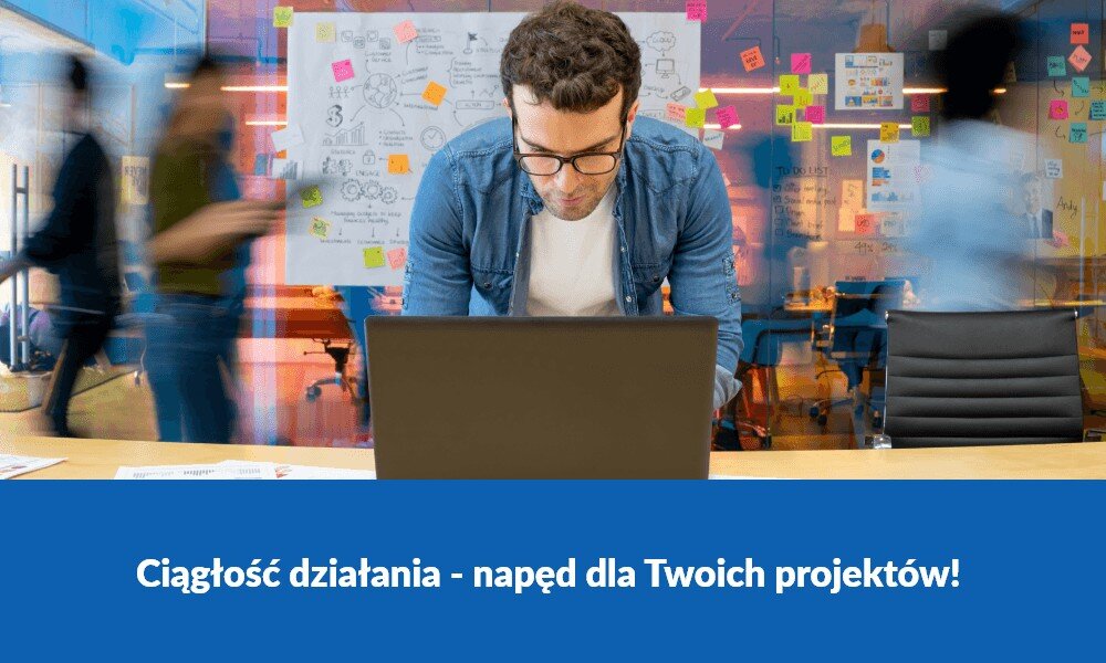Mężczyzna pracuje przy laptopie w biurze z tablicą pełną notatek w tle. Na dole obrazu widnieje napis: \'Ciągłość działania - napęd dla Twoich projektów!\'.