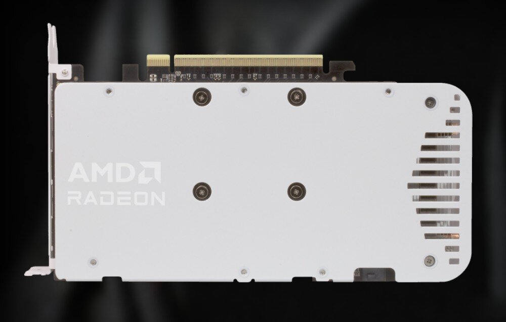 Karta graficzna POWERCOLOR Radeon RX 9060 XT Reaper 16GB Biały Widok tylnej części karty graficznej z metalową płytką ochronną i logo 'AMD Radeon'. W tle rozmyte światło na czarnym tle, komponenty, konstrukcja