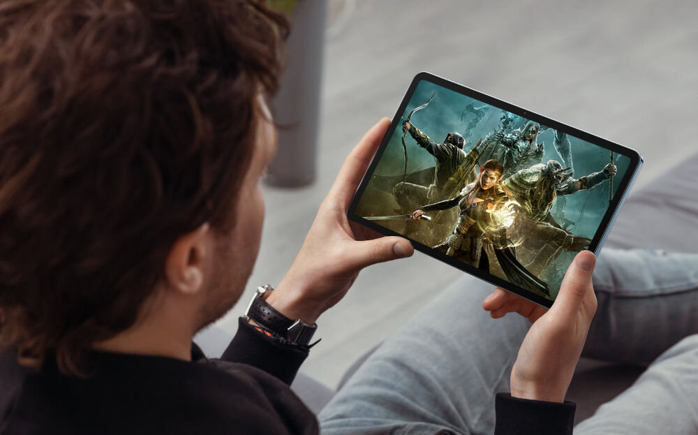 Tablet OSCAL Pad 100 12 cali 8/256 GB LTE Wi-Fi Szary prezentacja urządzenia granie w grę mężczyzna trzymający tablet bateria 900 mAh długie godziny pracy i rozrywki szybkie ładowanie 18 W