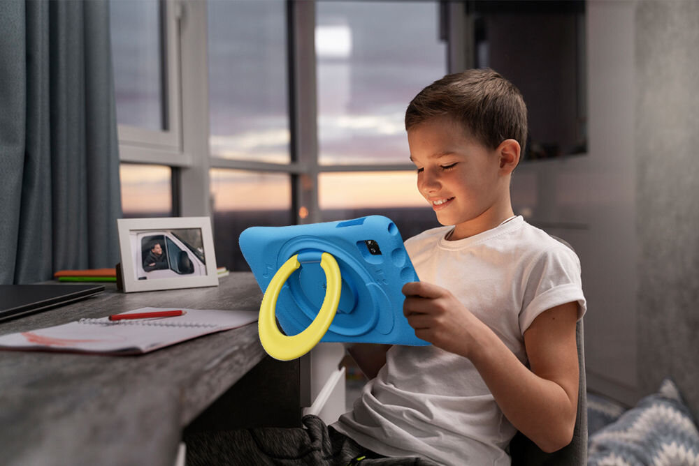 Tablet OSCAL Pad 60 Kids 10.1 cali 4/128 GB Wi-Fi Niebieski prezentacja urządzenia w codziennych warunkach chłopiec trzymajacy tablet w rękach w pokoju przy biurku notatki ośmiordzeniowy procesor Allwinner A523 ARM Cortex-A55 1.8 GHz 4 GB RAM 128 GB pamięci wewnętrznej wsparcie kart TF rozszerzenie pamięci przechowywanie materiałów edukacyjnych i aplikacji