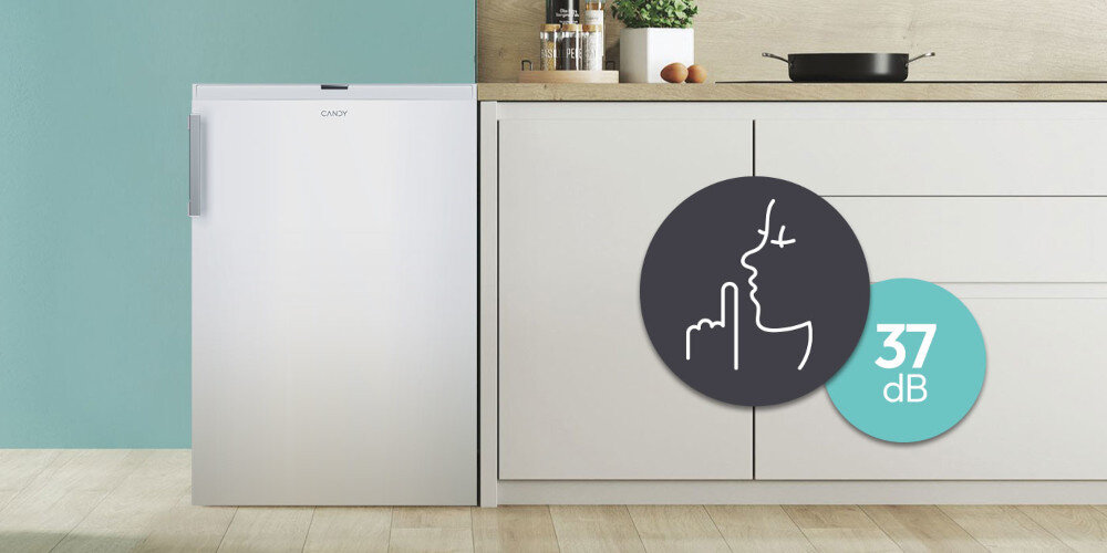 ZAMRAŻARKA CANDY CNUQ2L58EWH wizualizacja kuchnia szafki zabudowa dekoracje roślina poziom dźwięku w kółku kuchnia krzesło w tle ikona cicha praca Nie zaburzy domowego spokoju dźwięk około 37 db