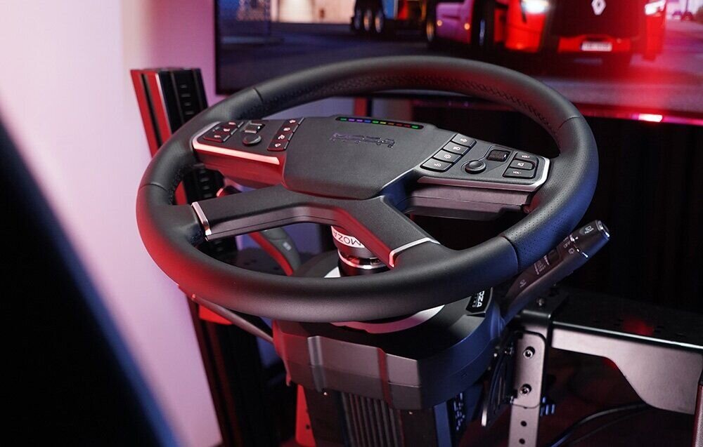 Manetki MOZA Racing RS065 Kierownica gamingowa z zamontowanymi manetkami stojąca naprzeciwko szerokiego monitora