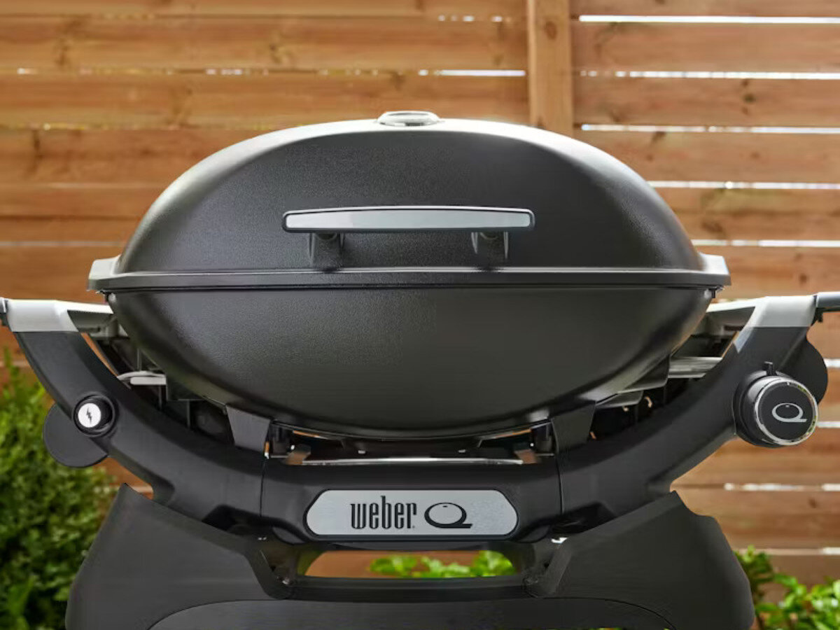 Grill gazowy WEBER Q 2200N 1501094 4.1 kW, pokrywa, termometr, deflektor, żeliwo, Zbliżenie na front grilla z logotypem Weber Q i pokrętłem.