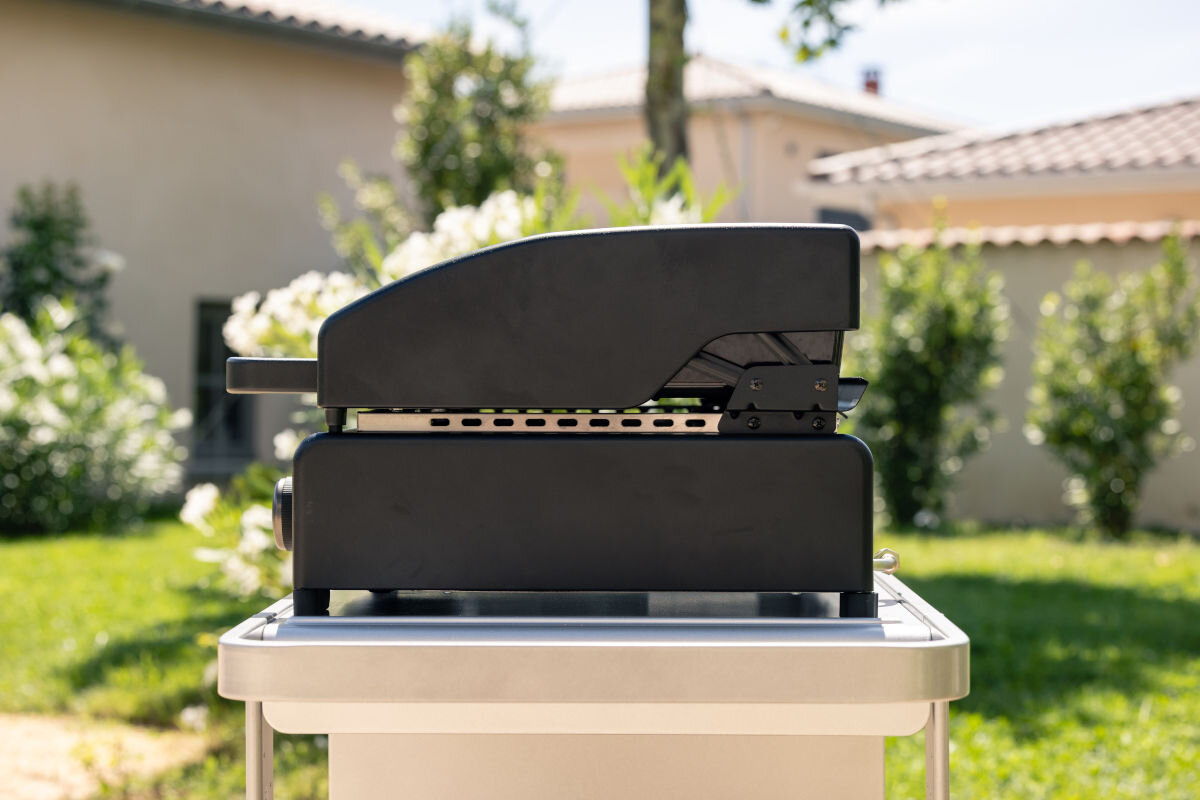 Grill gazowy CAMPINGAZ ONYX 2, pośrednie, przechowywania, kurz, zabrudzenia, w tle ogród, grill od bocznej strony frontem na wprost