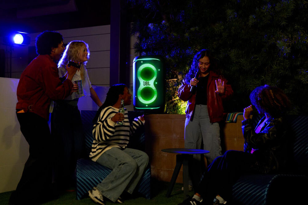 Power audio JBL PartyBox 520 - Zanurz się w świat muzyki, Power audio stojące na murku, osoby bawiące się w rytm muzyki