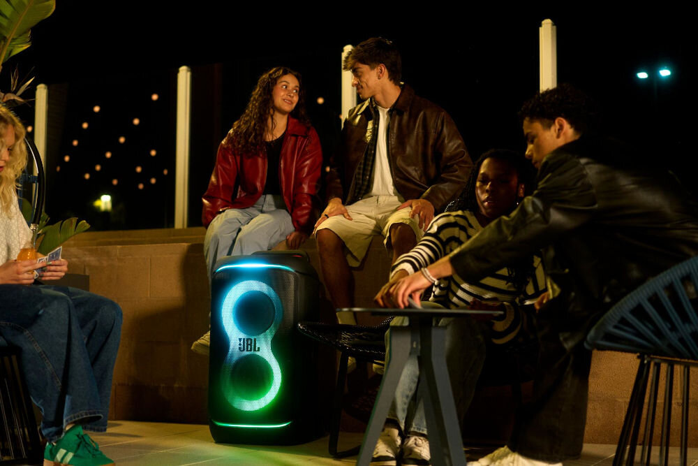 Power audio JBL PartyBox 520 - Z troski o środowisko, Obudowa wykonana z plastiku z recyklingu, Grupa młodych ludzi spędza wieczór na świeżym powietrzu przy muzyce płynącej z głośnika