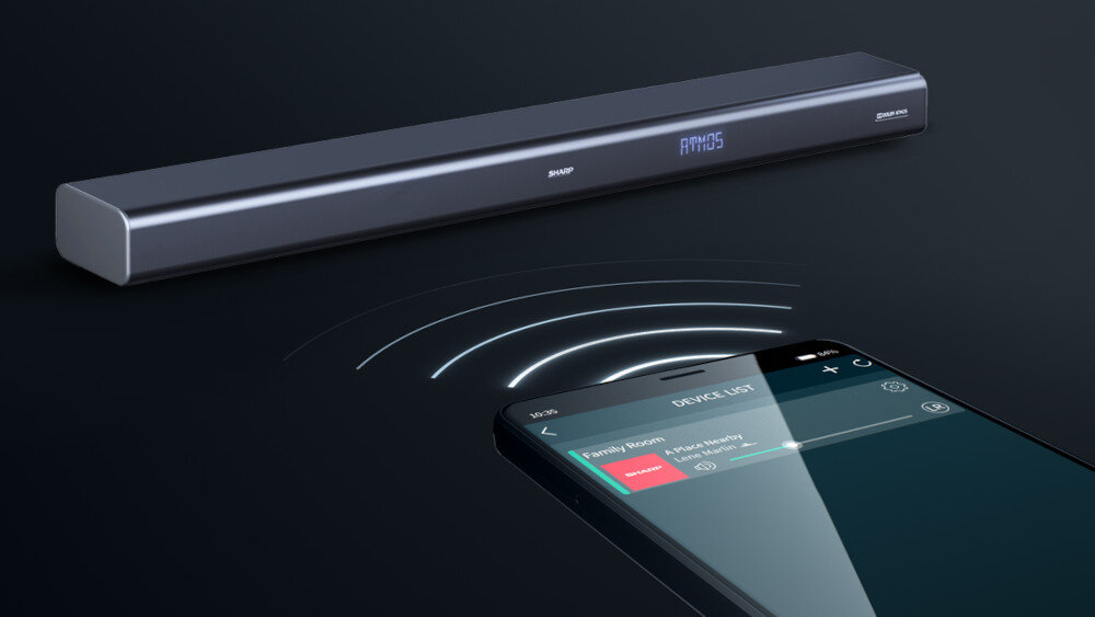 Na obrazie widoczny jest czarny soundbar z wyświetlaczem pokazującym napis \'ATMOS\'. Obok znajduje się smartfon z aplikacją pokazującą listę urządzeń, z którego emanują fale sugerujące połączenie bezprzewodowe.
