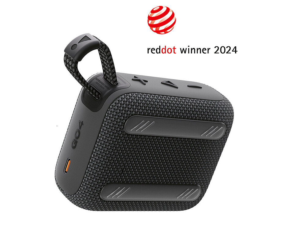 Czarny głośnik mobilny z teksturowaną powierzchnią i przyciskami na górze. Nad głośnikiem znajduje się napis \'reddot winner 2024\'.