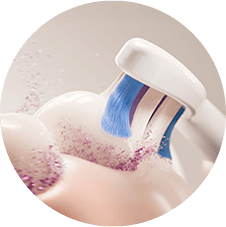 Zbliżenie na szczoteczkę usuwającą z zębów rozbitą płytkę.