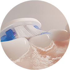 Zbliżenie na szczoteczkę czyszczącą zęby i wytwarzającą mikrobąbelki.