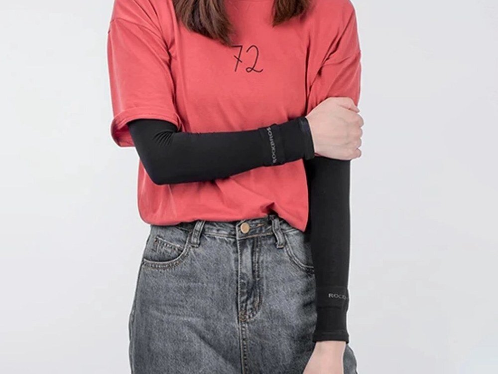 Osoba ubrana w czerwony t-shirt z numerem 72 i czarne rękawki rowerowe z napisem ROCKBROS. Osoba ma na sobie również szare dżinsy.