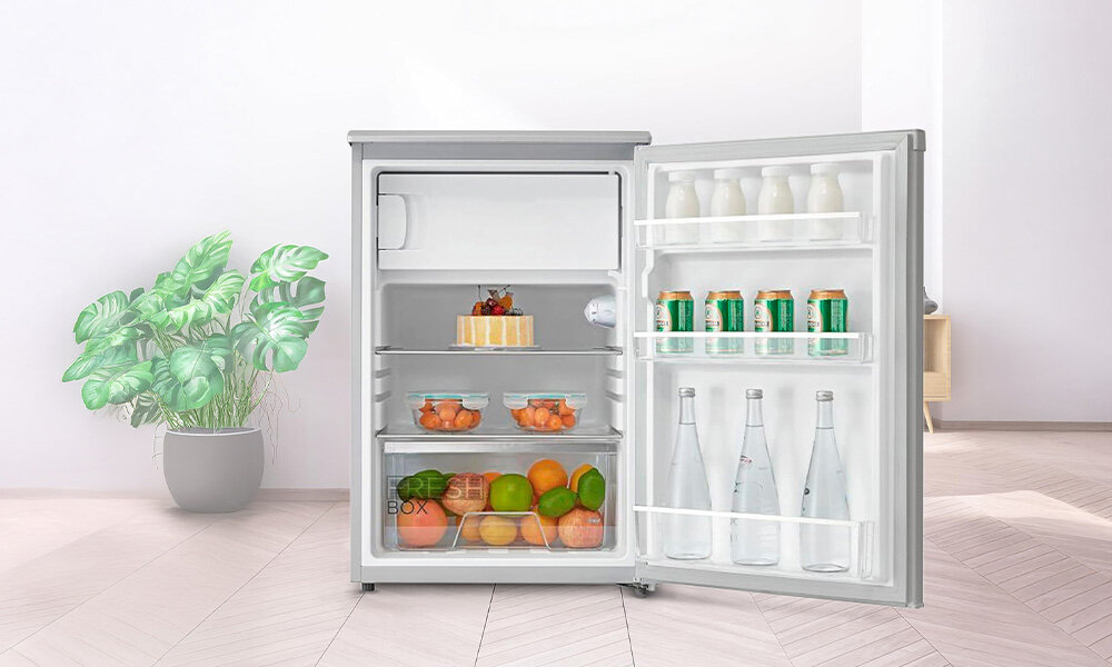 LODÓWKA MIDEA MDRD168FGE01 Otwarta lodówka wypełniona napojami, owocami i deserami wolnostojąca biała obudowa regulowane nóżki dopasowanie wnętrza