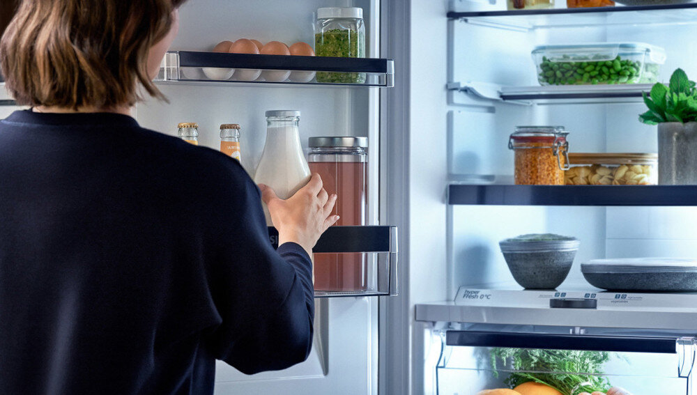 LODÓWKA SIEMENS KF96RSBEA Osoba sięga po butelkę z napojem z drzwi lodówki. Oświetlone wnętrze ułatwia szybkie znalezienie produktów szybkie chłodzenie napoje zakupy funkcja supercool Superchłodzenie