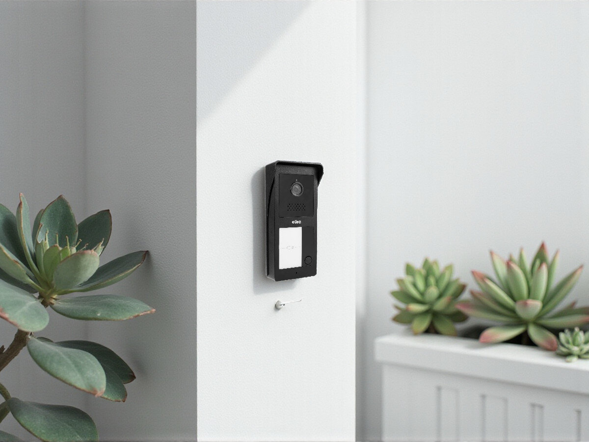 Wideodomofon EURA VDP-49A3-2TY Czarny, sterowanie, brama, mikrofon, komunikacja, Kaseta zewnętrzna EURA na słupku z roślinami, daszek ochronny, otwarta przestrwarta przestrzeń.