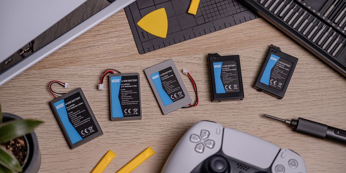 Akumulator NEWELL 650 mAh LIP1359 do kontrolera DualShock 3 Sony PlayStation 3, Pięć różnych akumulatorów Newell do kontrolerów gier ułożonych w rzędzie obok białego pada i narzędzi, bezłutowniczo, złącze, ergonomiczne, 40miesięcy
