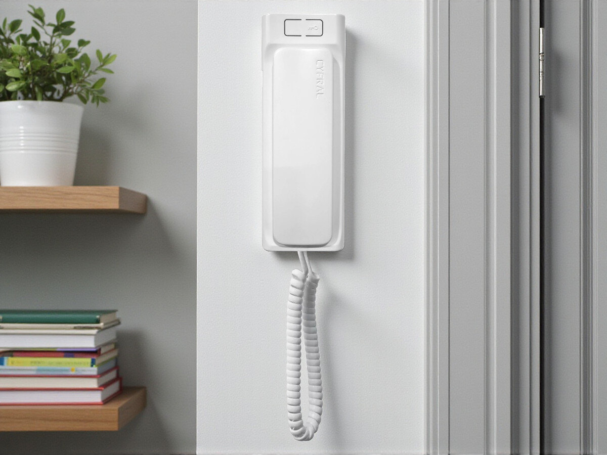 Unifon CYFRAL Baltic 2P Biały, obsługa, przyciski, montaż, codzienność, Widok unifonu Cyfral Baltic 2P w jasnym salonie, dalszy plan rozmyty, półki z książkami.