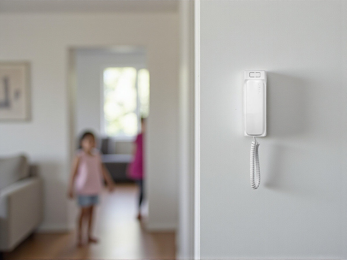 Unifon CYFRAL Baltic 2P Biały, głośność, regulacja, prywatność, instalacja, Unifon Cyfral Baltic 2P na ścianie, w tle dzieci w jasnym mieszkaniu