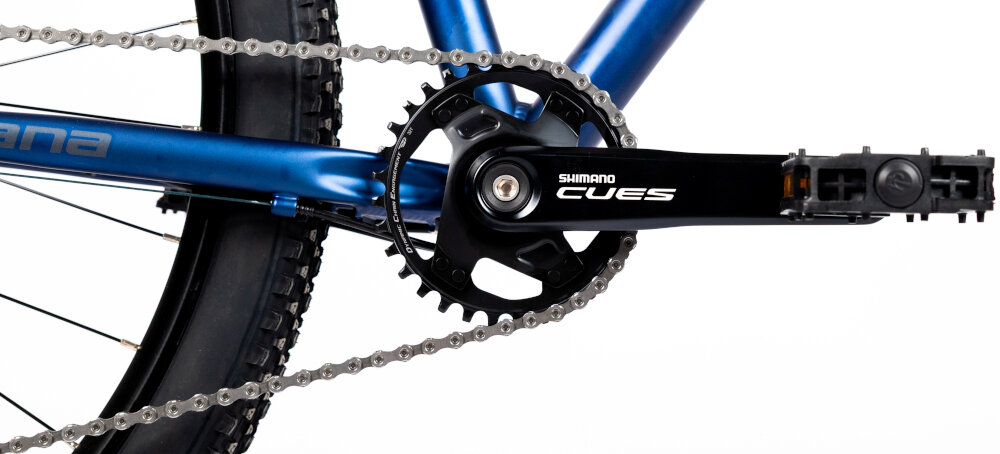 Rower górski MTB INDIANA X-Pulser 3.9 M21 29 cali męski Granatowo-srebrny zbliżenie na korbę kasetę i łańcuch lekka wydajna konstrukcja korby korba SHIMANO CUES typu AFCUT40012CA2 32T kaseta SHIMANO typu CSLG30010148 solidność wytrzyma bardzo duży nacisk na pedały