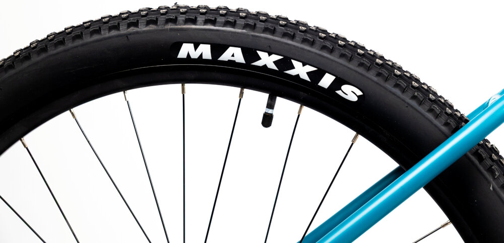 Rower górski MTB INDIANA X-Pulser 3.9 D16 29 cali damski Niebiesko-czarny zbliżenie na oponę rozmiar koła 29 cali łatwe pokonywanie przeszkód duży kontakt koła z podłożem szerokie opony marki MAXXIS dobra przyczepność dwukomorowe wzmocnione obręcze zachowanie regularnego kształtu kół stabilne trzymanie opony bezpieczna i komfortowa jazda regularne sprawdzanie ciśnienia powietrza wartość na bocznej części opony