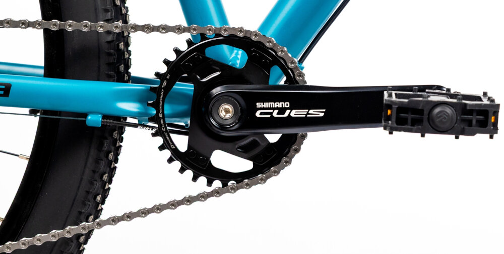 Rower górski MTB INDIANA X-Pulser 3.9 D16 29 cali damski Niebiesko-czarny zbliżenie na korbę kasetę i łańcuch lekka wydajna konstrukcja korby korba SHIMANO CUES typu AFCUT40012CA2 32T kaseta SHIMANO typu CSLG30010148 solidność wytrzyma bardzo duży nacisk na pedały