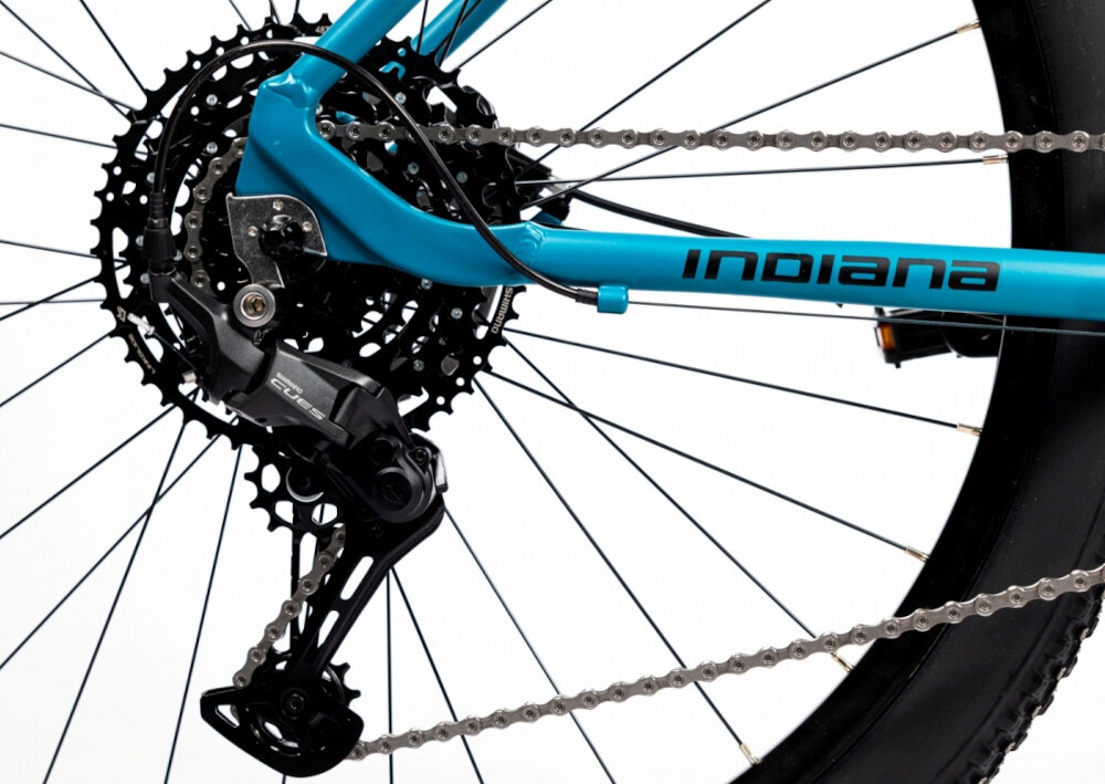 Rower górski MTB INDIANA X-Pulser 3.9 D18 29 cali damski Niebiesko-czarny zbliżenie na tylną przerzutkę przerzutki marki przerzutki marki SHIMANO 10 biegów tylny napęd SHIMANO CUES niewiarygodnie płynna i szybka zmiana przełożeń wytrzymałość