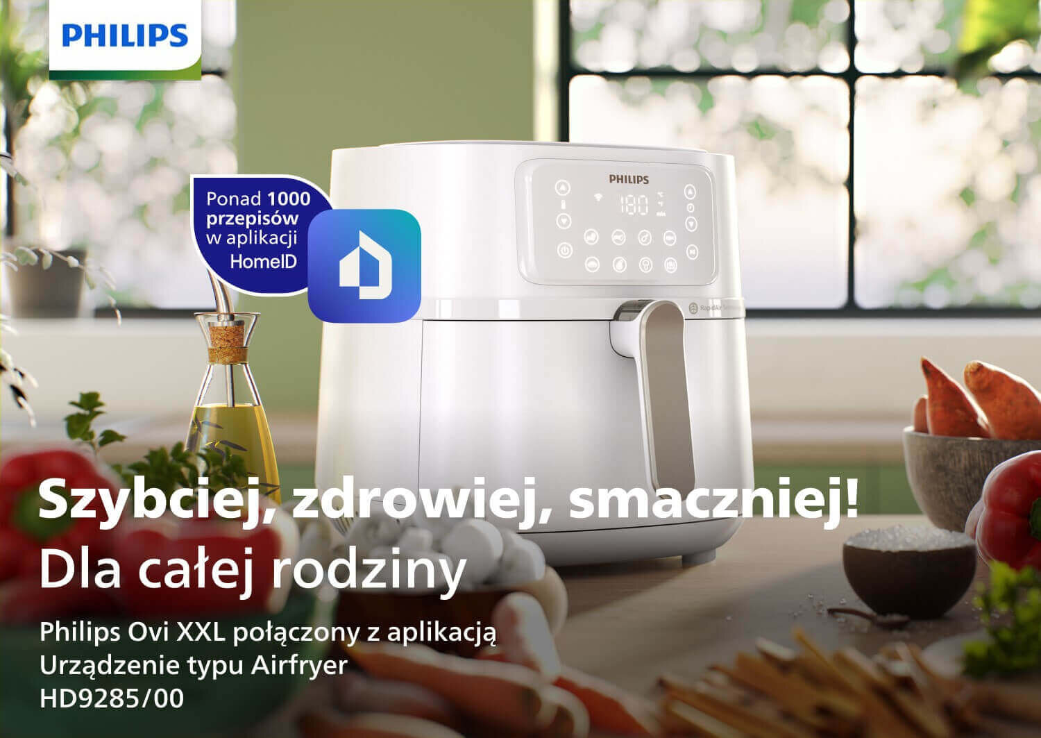 Na obrazie widoczna jest biała frytkownica beztłuszczowa z wyświetlaczem dotykowym, obok której znajdują się warzywa. Tekst na obrazie: \'Szybciej, zdrowiej, smaczniej! Dla całej rodziny Philips Ovi XXL połączony z aplikacją Urządzenie typu Airfryer HD9285/00\'.