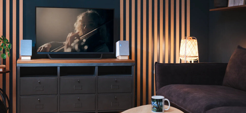 Kolumny głośnikowe ONKYO GX-10DB pasmo 70-20000 Hz skuteczność 110 dB, głośniki stojące na komodzie pomiędzy telewizorem