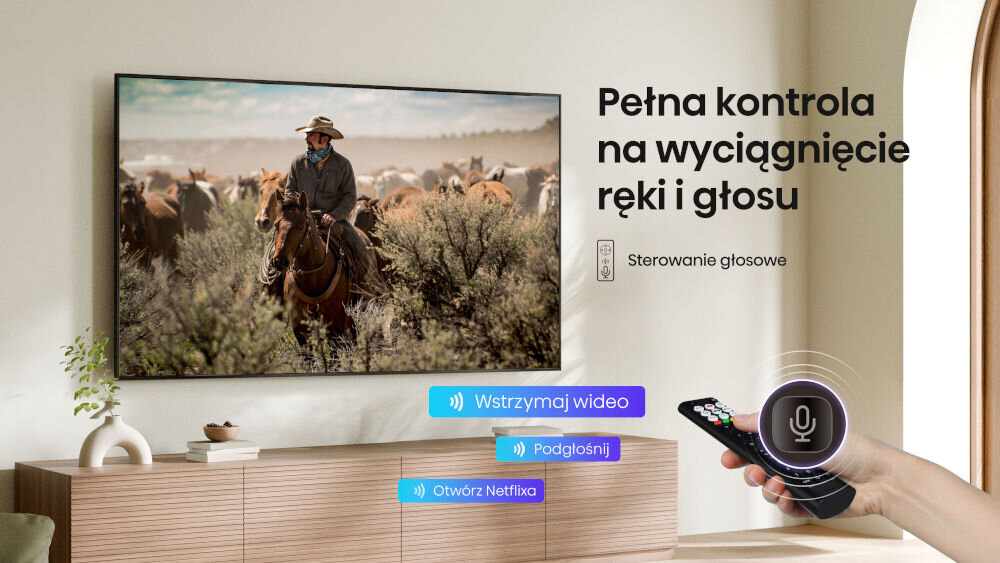 Telewizor HISENSE 75A6Q - Sterowanie głosem bez pilota, Voice Control, komendy głosowe, telewizor zawieszony na ścianie w salonie , ręka trzymająca pilota