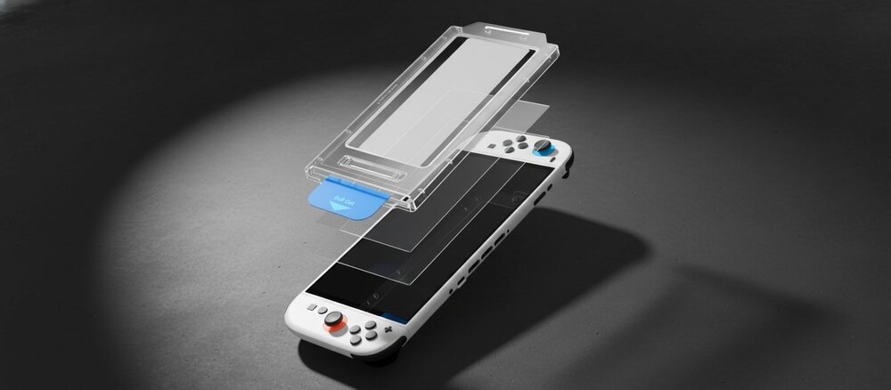 Biała konsola Nintendo Switch 2 leżąca pod reflektorem, nad ekranem kilka nałożonych warstw szkła ochronnego i przezroczysta ramka montażowa z niebieską zakładką ‘Pull Out’