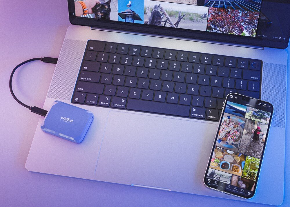 Dysk CRUCIAL X10 Dysk podłączony do laptopa i smartfona, na ekranach wyświetlane są zdjęcia, całość oświetlona jest kolorowym światłem, kompatybilność, systemy, szyfrowanie