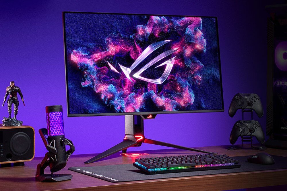Monitor ASUS ROG Swift PG32UCDM Monitor stojący na biurku gamingowym z podświetlaną klawiaturą, dwoma kontrolerami do gier, mikrofonem z fioletowym podświetleniem oraz figurką postaci z gry, ekran, przekątna, rozdzielczość, odświeżanie, czas reakcji