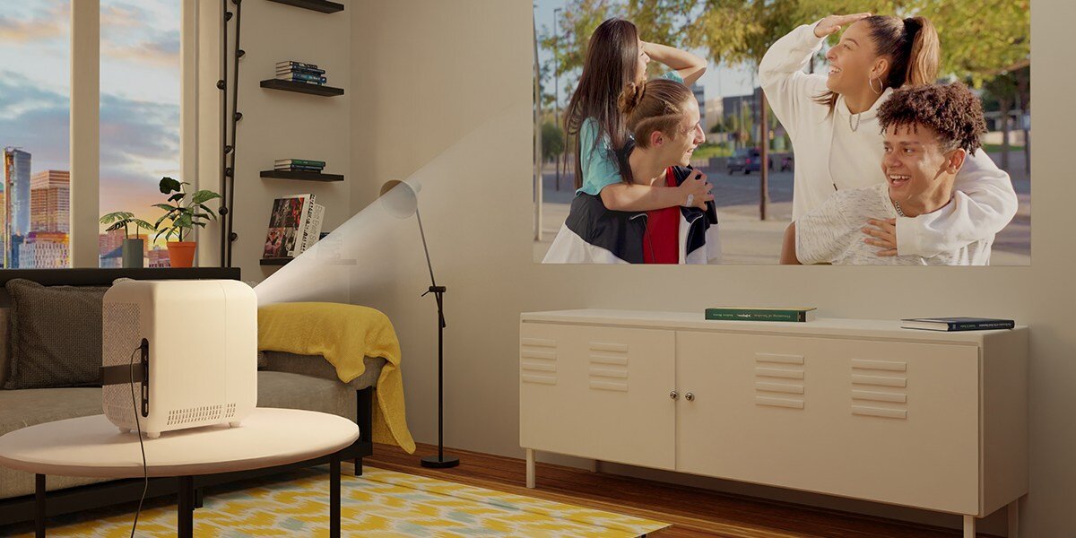 Projektor HP CC180W - Wyraźny obraz w HD, rozdzielczość 1280 × 720 px, LCD, Proporcje 16:9, Ekran o wielkości 45–80 cali, projektor stojący na stoliku, wyświetlający obraz na ścianie pokoju