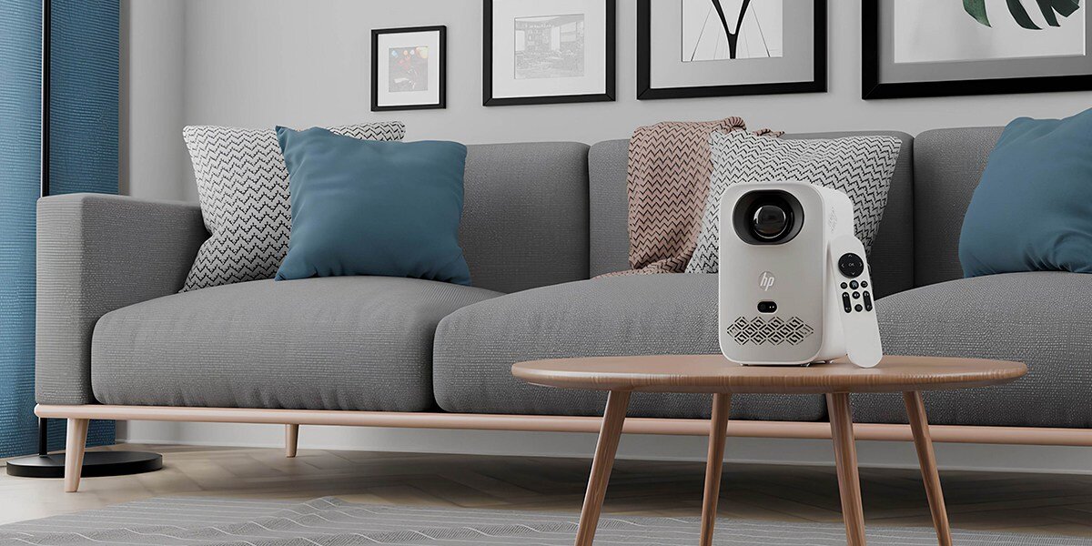 Projektor HP CC360 - Kino zawsze pod ręką, projektor z pilotem stojący na stoliku w pokoju