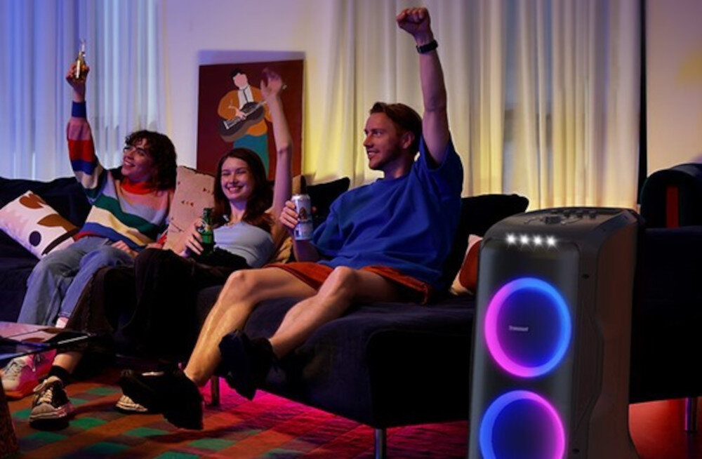 Power Audio TRONSMART Halo 300 system 2.2 trzydrożny woofer tweeter bogate pasmo, osoby siedzące na kanapie, power audio stojące obok kanapy