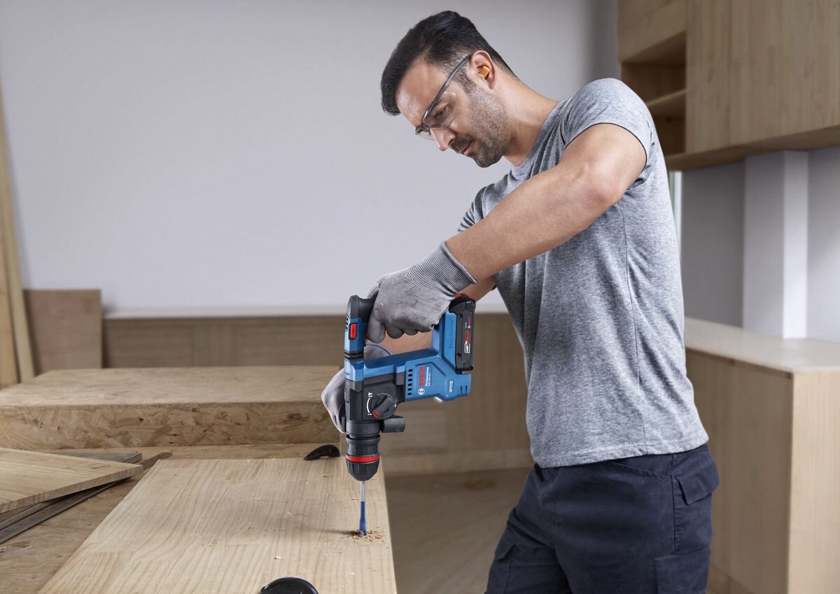 BOSCH Professional GBH 18V-18 X 0611927102 KickBack Control urządzeniami bez tej funkcji - Mężczyzna wierci otwór w drewnie, korzystając z akumulatorowego młota udarowo-obrotowego